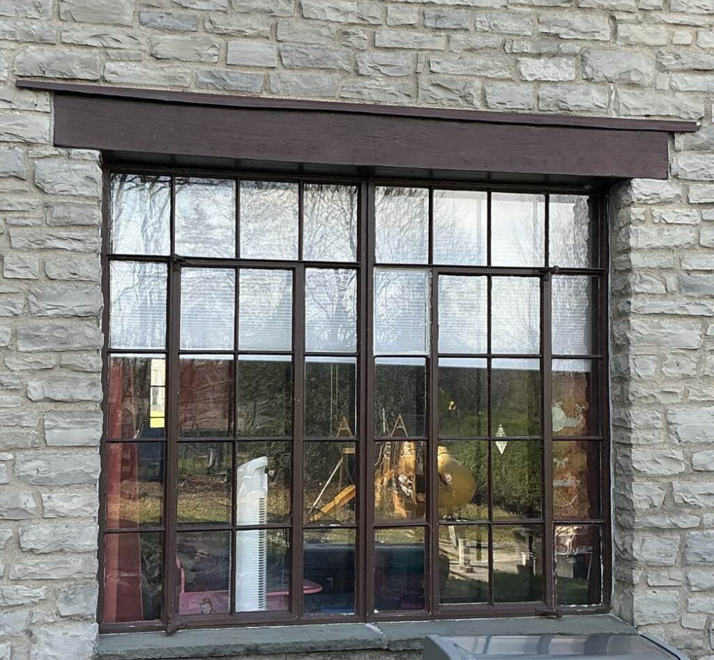 Old window exterior with worn wooden frames Outdated, drafty, original windows before New York Sash upgraded this home.