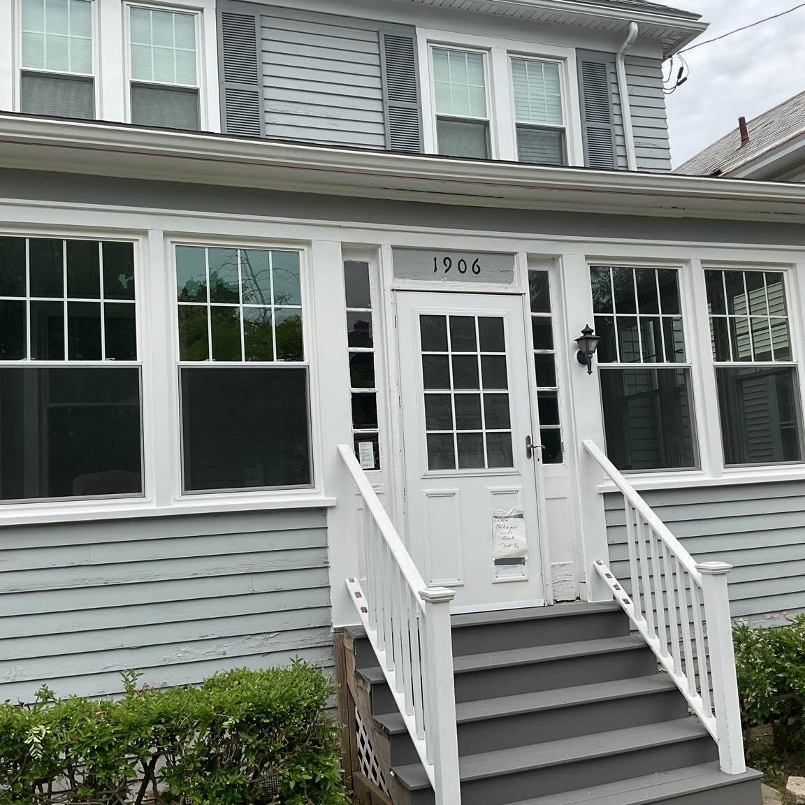 Newly installed vinyl replacement window and a complementary decorative entry door by New York Sash on a renovated home in Utica, NY