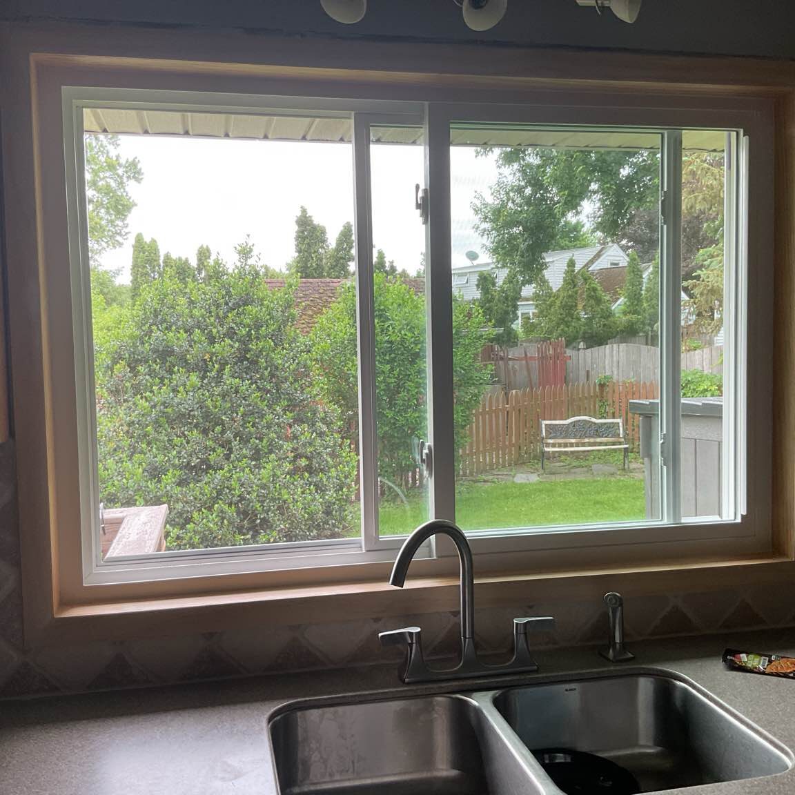 A modern sliding window installed above a kitchen sink, providing easy access to fresh air and natural light in the cooking space.