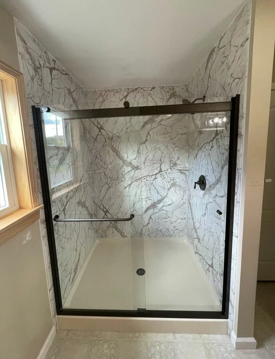 New walk-in shower with patterned wall surround and accessories